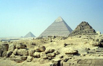 [Rock wall in front of pyramids]